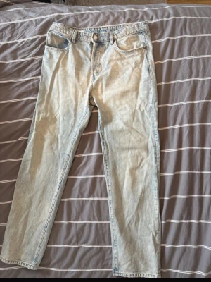 Ljusblå raka jeans från zara - Säljer ett par ljusblå jeans med rak passform och klassisk femficksdesign. Jeansen har normal midja och stängs med knapp och dragkedja. Perfekta för en avslappnad och trendig look.