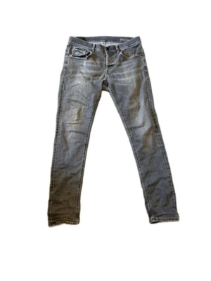 Smala Grå Jeans - Ett par schyssta Dondup George i storlek 34. Jeansen har slitningarna i fickorna och på baksidan. Det finns ett litet hål i skrevet som är väldigt lätt att fixa. OBS 🚨Egenlagad hål i slitningarna på baksidan från tidigare ägaren.