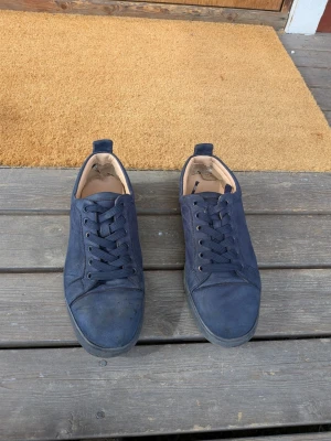 Mörkblå sneakers med röd sula - Christian Louboutin skor☺️ De är i fint skick men är ganska slitna vid sulan (se sista bilden) Skicka om du har några frågor😁