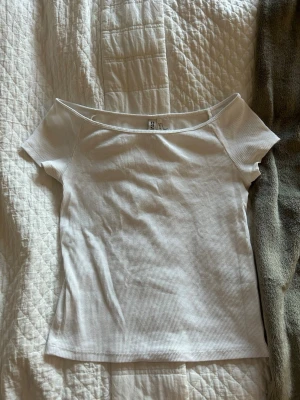 Vit ribbad topp från H&M - Säljer en jättefin vit smal ribbad topp från H&M i jätte bra skick! Man kan använda den vanligt eller off shoulder, i storlek S💕💕