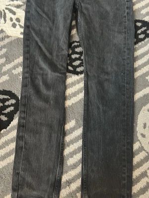 Svarta raka jeans - Snygga svarta jeans med rak passform och klassisk femficksdesign. Jeansen har en något tvättad look och är perfekta för en avslappnad stil. Materialet är denim och de har normal midja.