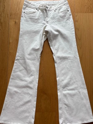 Lowrise vita bootcut jeans från Zara - Säljer ett par vita bootcut jeans med låg modja. Helt oanvända men saknar prislappen. Jeansen är från Zara 