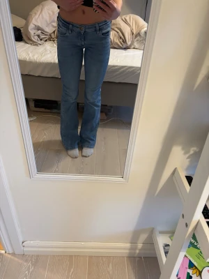 Ljusblå bootcut jeans LEE - Säljer ett par ljusblå bootcut jeans med medel låg. Jeansen har en snygg tvätt och är tillverkade i denim med lite stretch. Jeansen är i storlek w25 L31. Dem är i bra skick men har gått sönder lite nere vid fötterna för att jag har trampat på dem. De kostar ursprungligen 1100kr och är från märket LEE.