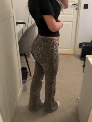 Leopardmönstrade utsvängda jeans - Säljer ett par snygga leopardmönstrade jeans från Nelly i storlek 34. Säljer då de tyvärr ej används. Endast använda en gång.