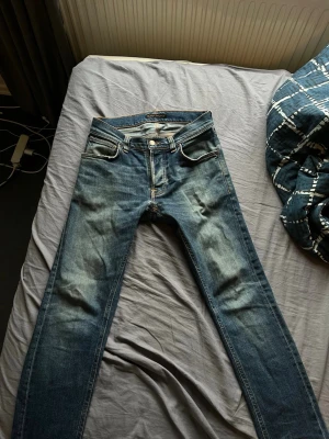 Nudie jeans - Skitsnygga blåa jeans från Nudie. Passar till allt och verkligen en tidlös plagg i storlek 27W. Jätte bra skick förutom ett litet hål i fickan där av det billiga priset