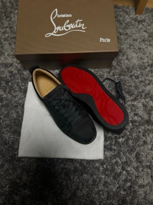 Mörkgråa Louboutin modell louis junior. - ag Säljer dessa då jag har för många skor i garderoben och dessa förtjänar att användas. ett par exklusiva Louboutin-skor i storlek 44 med den klassiska röda sulan. Modellen är helt utan spikar – ren, elegant och tidlös design. Perfekta både till vardaglig stil och mer dressade tillfällen.  Yttersidan av skon är gjord av materialet kalvmocka, även kallad veau velours, fodret är gjort av kalvskinn som anses vara de mest högkvalitativa lädermaterialen som finns.  Skorna är i mycket fint skick, end