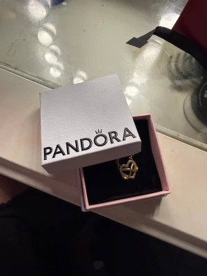 Guldigt halsband från Pandora - Snyggt halsband från Pandora i guldton med ett hjärtformat hänge. Hänget har en infinity-symbol och är dekorerat med små gnistrande stenar för extra bling. Kedjan är tunn och elegant, perfekt för att lyfta vilken outfit som helst. Köpt för 1400kr 