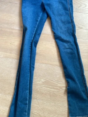 Blå skinny jeans från Grunt - Säljer ett par blå skinny jeans från Grunt med klassisk femficksdesign och svarta läderdetaljer på bakfickan. Jeansen har smal passform och är gjorda i stretchigt denim-material som sitter snyggt och bekvämt. Jag är inte direkt ett fan av skinnet så det är därför jag säljer och också för att man kan ju sy om den till t.ex en jeanskjol!❤️🫶