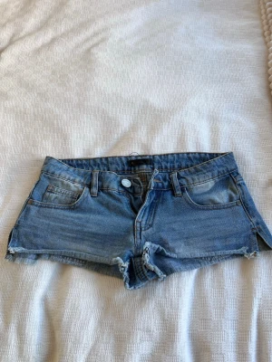 Blå jeansshorts från Sinsay - Snygga blå jeansshorts från Sinsay, jättelågmidjade, och vintage. Inga defekter alls. Perfekt till sommaren!!   