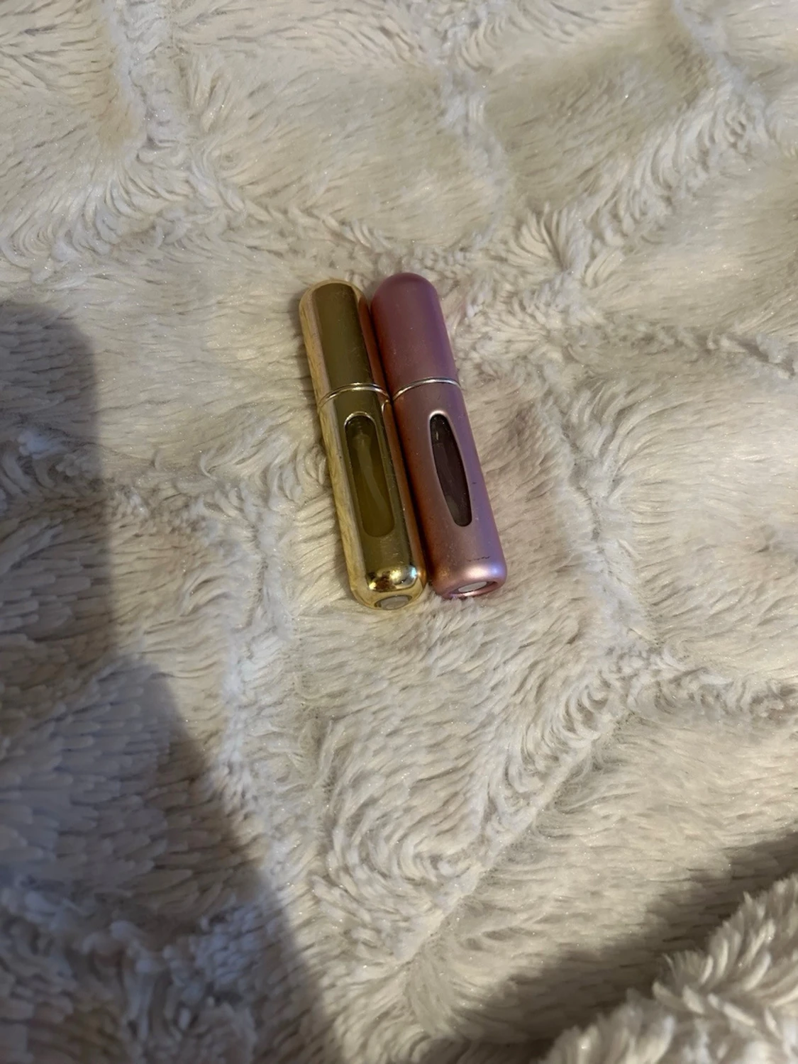 Två parfymatomizers i guld & rosa