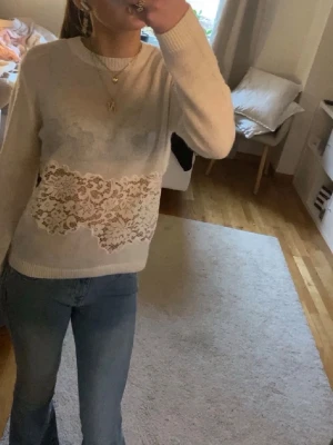Vit tröja med spetsdetalj - Säljer en vit trendig långärmad tröja med snygg spetsdetalj över magen från Zara! Perfekt för dig som gillar en romantisk och stilren look 🥳😍 Den är nopprig men har inte hål osv 