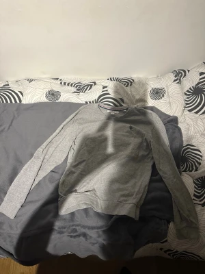 Grå sweatshirt från US Polo Assn - Snygg grå sweatshirt från US Polo Assn med rund halsringning och diskret logga broderad på bröstet. Tröjan har långa ärmar och är gjord i mjukt bomullsmaterial. Perfekt för en avslappnad och stilren look.