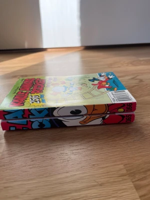 Kalle Ankas Pocket nr 165 & 166 - Två färgglada Kalle Ankas Pocket-böcker, nummer 165 och 166. Omslagen har tecknade motiv med Kalle Anka. Går att köpa 20 kr/st eller alla för 30 kr 