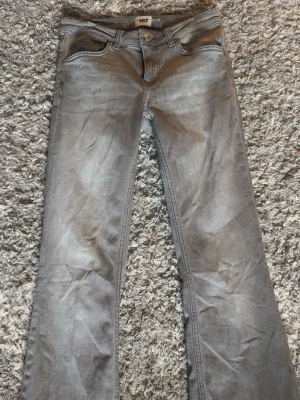 Gråa low bootcut jeans från 157 - Säljer ett par gråa bootcut jeans från 157 med klassisk femficksdesign. Modellen är low boot, short length i storlek S❤️innerbenslängden är 74 cm❤️ skriv vid funderingar