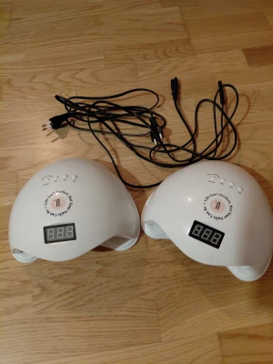 UV/LED-lampor  - Säljer 2st UV/LED-lampor, köpta från Nailster och har använts ca 5 gånger. Lamporna har en digital display och tre knappar för timer 30, 60, 90 sekunder. Bottenplattan är löstagbar för att underlätta vid pedikyr. Jag säljer helst lamporna tillsammans.