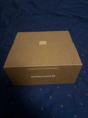 Meta Quest 3S VR-glasögon med kontroller - Meta Quest 3S VR-glasögon i vit och svart design, levereras med två matchande handkontroller. Snygg och modern form, tillverkad i plast med justerbart huvudband för bekväm passform. Perfekt för VR-spel och upplevelser.