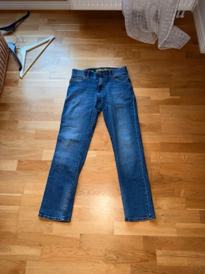 Blå Lee Extreme Motion jeans - Säljer ett par blå Lee Extreme Motion jeans med klassisk femficksdesign och rak passform. Jeansen har normal midja och är gjorda i stretchigt denim för extra komfort. Perfekta för dig som vill ha både stil och rörelsefrihet. Det står straight fit men skulle säga att dem sitter lite tajtare. 