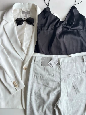 Clean it-girl outfit bundle: kostymbyxor + kavaj + satinlinne + solglasögon - Clean girl inspirerad outfit bundle 🖤  Kit med 4 delar: • grå kostymbyxor, stl 42 (nya med prislapp) • vit kavaj, stl S (lite smuts på ena ärmen - knappt synbart, se bild nr. 4)  • svart satinlinne, stl S • svarta solglasögon  FLER BILDER FINNS!   Perfekt clean vår-outfit 🌿 Den vita kavajen ska kemtvättas. Den har dock gått en gång i tvättmaskin och det gick alldeles utmärkt! Kolla gärna mina andra kit 💌