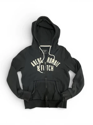 Abercrombie & Fitch zip hoodie - Säljer en snygg mörkblå Abercrombie & Fitch zip hoodie. Bra skick, storlek M.  Mått: Längd: 60 cm Axelbredd: 39 cm  Skriv vid vidare funderingar!