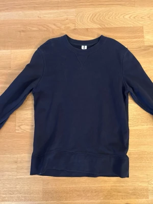 Mörkblå sweatshirt  - En basic mörkblå sweatshirt i mjuk bomull med rund halsringning och ribbade muddar. Enkel och stilren design som passar perfekt till jeans eller joggers. Tröjan har klassisk passform och är riktigt skön att ha på sig.