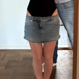 Blå jeanskjol från Pieces  - Säljer en kort lågmidjad jeanskjol i klassisk blå denim med rå, fransig nederkant. Står ingen storlek men skulle säga att den passar xs!