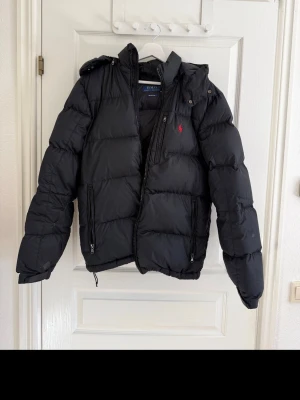 Svart pufferjacka från Polo Ralph Lauren - De finns lite defekter men inget man tänker på den är riktigt skön o pris kan diskuteras vid snabb affär
