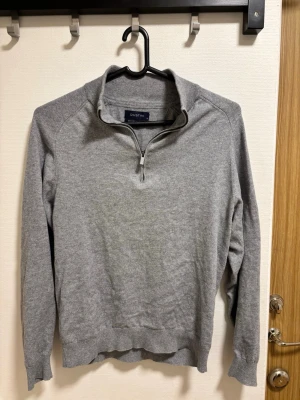 Grå halvzip-tröja cashmere - Snygg grå tröja från Dustin med halv dragkedja och hög krage. Tillverkad i mjukt material, perfekt för lager på lager. Långärmad modell med ribbade muddar och avslut. Enkel och stilren design som passar till det mesta.