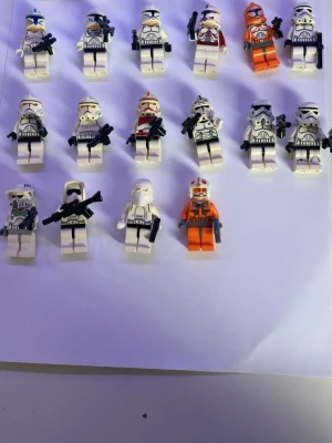 LEGO Star Wars minifigurer mix - Säljer ett gäng LEGO Star Wars minifigurer, mestadels olika typer av stormtroopers och klontrupper i vitt, svart och orange. Flera har detaljerade hjälmar och vapen. Några figurer har orange dräkt och vissa har unika hjälmdesigner. Perfekt för samlare eller Star Wars-fans.
