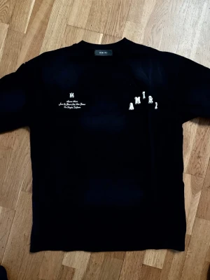Svart t-shirt från Amiri ”Oversize” - Svart t-shirt från Amiri med vit text och logga på bröstet. Klassisk rund halsringning och korta ärmar. T-shirten är av oversize modell. Storlek M.