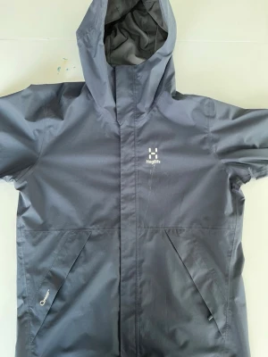 Haglöfs vindjacka - Bra skick//Har enbart några skador kolla bilderna//Skadorna syns knappt vid användning//Mycket lågt pris och priset kan bli lägre vid snabb köp//Hör av dig vid fundering!