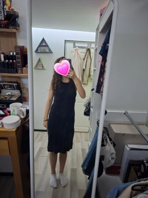 Svart ärmlös klänning - Säljer en enkel och stilren svart klänning med ärmlös design och rund halsringning. Klänningen har en rak passform och slutar strax ovanför knäna, vilket ger en klassisk look. Perfekt enkel klänning till sommaren.