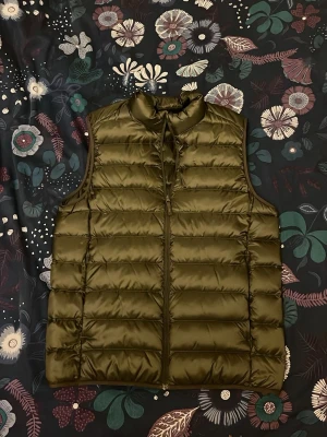 Väst Uniqlo - Snygg olivgrön dunväst från Uniqlo storlek S passar även xs. Aldrig använd.  Skriv gärna vid frågor eller funderingar !