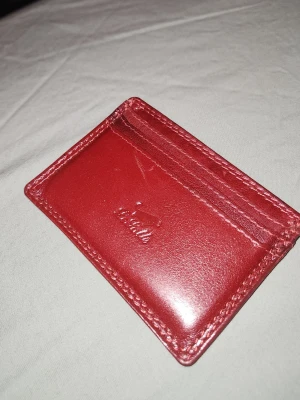 Vinröd korthållare - Den ser lite ljusare ut i bilderna men den är mörkare i verkligheten. Den är I nyskick och säljer då jag inte gillar färgen. 