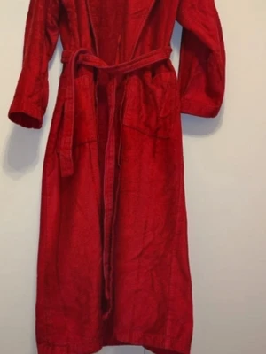 Röd morgonrock med skärp - Mysig röd morgonrock i mjukt tyg med klassisk krage och matchande midjebälte. Två stora fickor framtill och långa ärmar gör den perfekt för chilliga morgnar eller kvällar. Enkel och stilren design utan synligt märke.