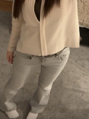 Ljusgrå bootcut jeans  - Säljer ett par ljusgrå bootcut jeans och klassisk femficksdesign. Jeansen har normal midja och bälteshällor. Perfekta för en avslappnad och trendig look. Helt nya, använt 1 gång 