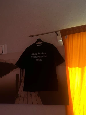 Acne Studios - Sommaren är på väg. Du vet den där känslan när solen värmer och du bara vill ha på dig något enkelt, mjukt och snyggt? Den här svarta t-shirten från Acne Studios. Oversized passform, rund halsringning. Perfekt till jeans, shorts, eller vad fan du vill.  Materialet är galet mjukt, du kommer inte vilja ta av den. Passar till allt, hela sommaren. Lita på mig.  OBS: Passar M/S