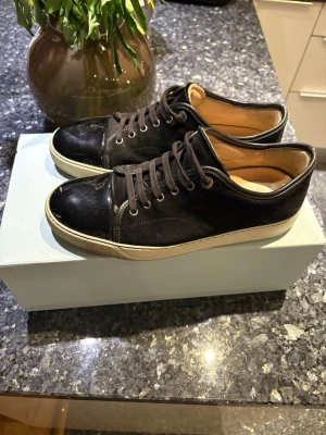 Svarta Lanvin sneakers i läder och mocka - Köpta på care of carl i vintras för 4700, kvitto finns. Lite smutsiga annars toppen skick. 