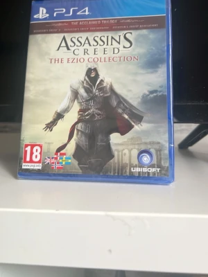 Assassin's Creed The Ezio Collection PS4 - Assassin's Creed The Ezio Collection till PlayStation 4. Samlingsutgåva med flera spel i serien, där du följer lönnmördaren Ezio Auditore. Omslaget är i blå plast med snyggt tryck och spelet är PEGI 18. Perfekt för dig som gillar action och äventyr.