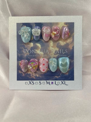 CupidSoda (L);ExtraShortAlmond  - Handgjorda press-on naglar i pastellfärger med söta 3D-motiv som katt, regnbåge, rosett och enhörning. Mix av blått, lila, rosa och glitter, dekorerade med pärlor och små detaljer. Perfekt för dig som vill ha unika och kreativa naglar.L: 17 mm, 12,5 mm, 13 mm, 12 mm, 10 mm 