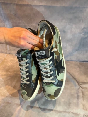 Golden goose  - Hej, säljer dessa otroligt sällsynta Golden Goose camo - i size 44, perfekt för sommaren och jätte bra skick - Nypris= 5000 SEK - Mitt pris= endast 2290 SEK - kvitto finns 🦚