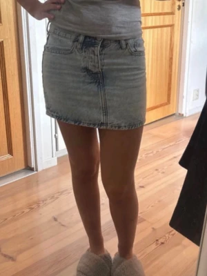 Ljusblå jeanskjol i kort modell - Trendig ljusblå jeanskjol ifrån lager 157 i storlek xxs. Kjolen har en kort passform och är tillverkad i denim med snygga slitningar framtill. Perfekt för dig som gillar en avslappnad och cool stil. 