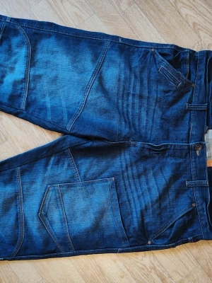Blå jeansshorts shorts herr stl 42 passar XL - Säljer ett par coola blå baggy jeansshorts. Jeansen har en avslappnad passform för en streetig look. Perfekta för dig som gillar en avslappnad och trendig stil. Märkta stl 42 men passar min son som är XL. Mått tvärs över midjan är ca 54cm. Fint skick.