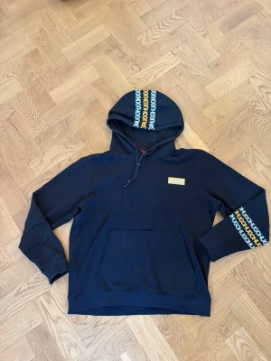Hugo Boss Hoodie  - Svart Hugo Boss hoodie med stilrena detaljer på ärmar och huva som ger den en exklusiv look. Bekväm passform och mjukt material som passar perfekt till både vardag och streetwear. Tröjan har en del slitage/skavanker som syns på bilderna.