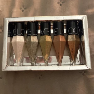 L.O.V ögonskuggset metallic 6-pack - Set med sex flytande eyeliners från L.O.V i metallicfärger som champagne, guld, brons och koppar. Varje eyeliner har en unik diamantformad flaska med svart lock och skimrande finish. Perfekt för kreativa och glittriga ögonmakeuper. Aldrig använt!! 