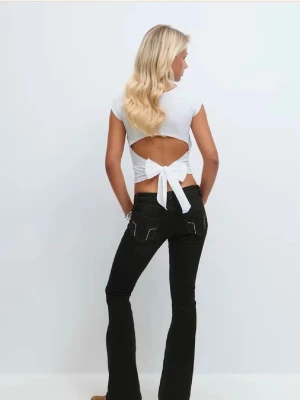 Svarta bootcut jeans med broderi - Säljer ett par svarta bootcut jeans med snygga detaljer på bakfickorna. Klassisk femficksmodell med knapp och dragkedja framtill. Jeansen är utsvängda och passar till allt!🤗🤗