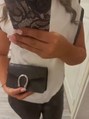 Svart väska med kedja - En jättefin svart väska med silvrig kedja