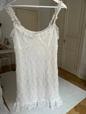 Vit spetsklänning - Super söt klänning från Pull & Bear, i storlek L, aldrig använd. Perfekt för sommarens alla tillfällen och ger en fräsch och feminin look.