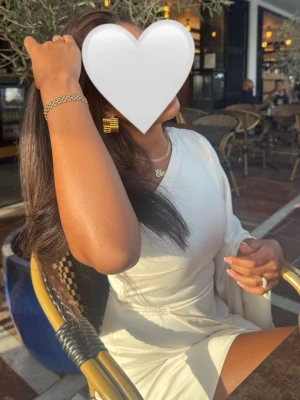 Vit oneshoulder kortklänning - Snygg vit kortklänning med oneshoulder-design och lång ärm på ena sidan. Klänningen har en stilren och modern look, perfekt för dig som vill sticka ut. Tillverkad i ett mjukt tyg som ger en bekväm passform och markerar midjan på ett smickrande sätt. Perfekt till studenten 😊