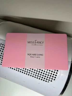 Miss Fancy Square Long Deep C-curve  - Tippar från Miss Fancy Professional i modellen Square Long med Deep C-curve. Naglarna är transparenta och kommer i en rosa förvaringsbox med flera storlekar sorterade i fack. Perfekt för dig som vill ha långa, fyrkantiga naglar med tydlig kurva.