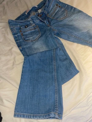 Bootcut jeans från Only - Säljer ett par ljusblå bootcut jeans från Only med klassiska fem fickor och snygga slitningar. Jeansen har låg midja och vida ben (bootcut eller straight). Storlek W32(XXS),L32.   OBS! På bild 5 kan man se LIKNANDE jeans på, och dessa till höger💗Mått: Midjemått tvärsöver: ca 33cm. Innerbenslängd: ca 75cm. Pris kan diskuteras😊